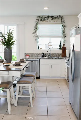 a kitchen with stainless steel appliances kitchen island granite countertop a table and chairs in it