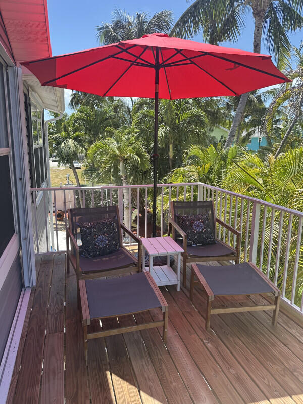 1109 76 Street, Unit OCEAN Marathon, FL 33050 - Photo 4 of 24 a view of a balcony with chairs and wooden floor