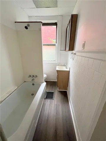 a bathroom with a tub a sink and a window