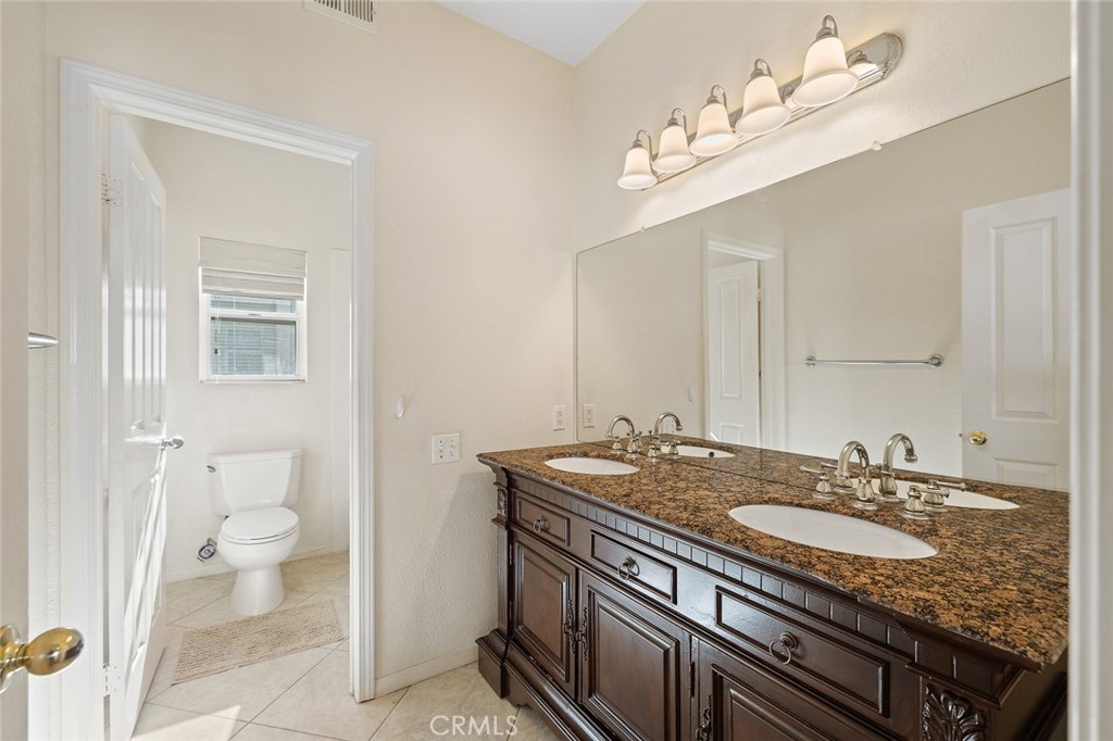33686 Bridgehampton Drive Dana Point, CA 92629 - Photo 18 of 29 a bathroom with a granite countertop sink a toilet and a mirror