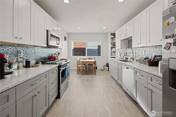a kitchen with stainless steel appliances granite countertop a refrigerator sink and stove