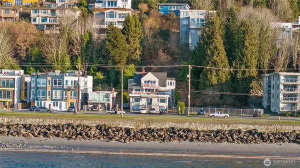 a view of swimming pool with lawn chairs and plants