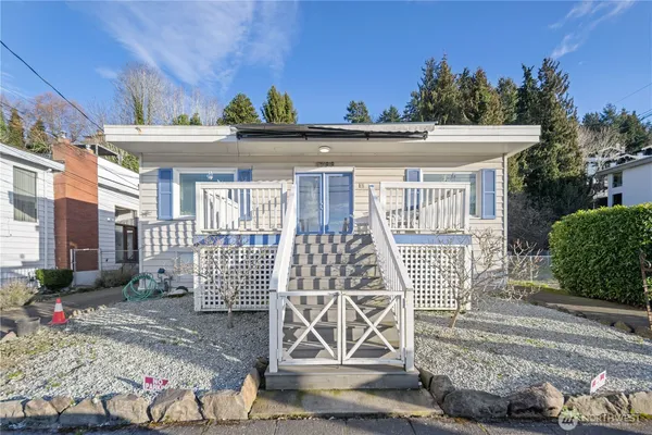 a front view of a house with a tree