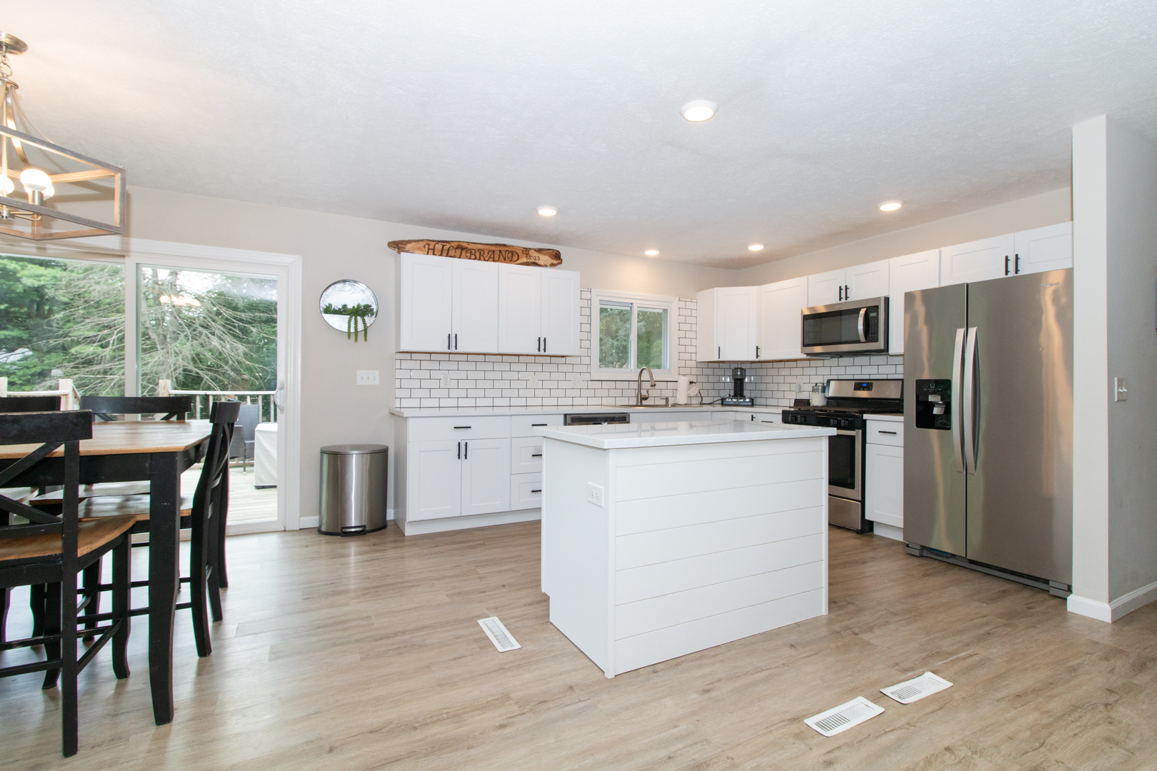 211 Sandra Lane Normal, IL 61761 - Photo 2 of 44 a kitchen with a refrigerator a microwave a stove and a dining table with wooden floor