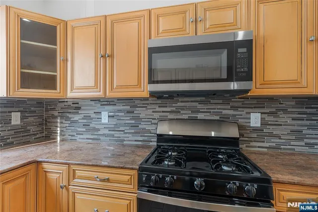 a kitchen with granite countertop a stove and a microwave