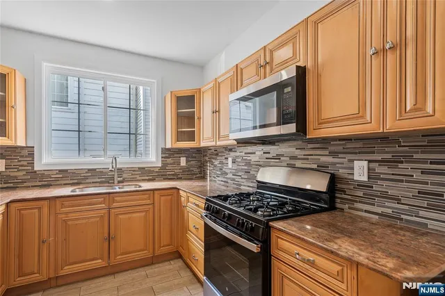 a kitchen with stainless steel appliances granite countertop a stove a sink and dishwasher
