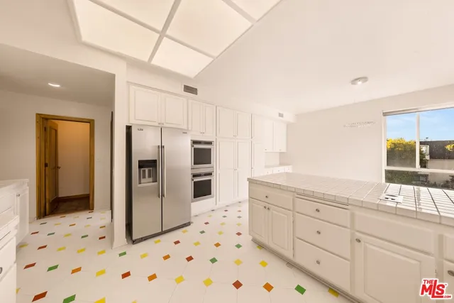 a spacious bathroom with a double vanity sink a large mirror and shower