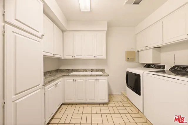 a kitchen with granite countertop a stove a sink and a refrigerator