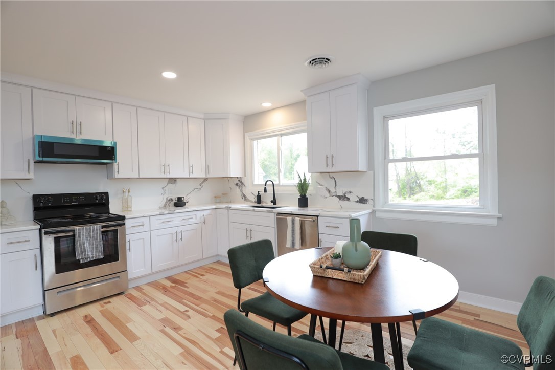 6626 Willson Road Henrico, VA 23231 - Photo 14 of 43 a kitchen with stainless steel appliances granite countertop a stove a kitchen island a table and a sink