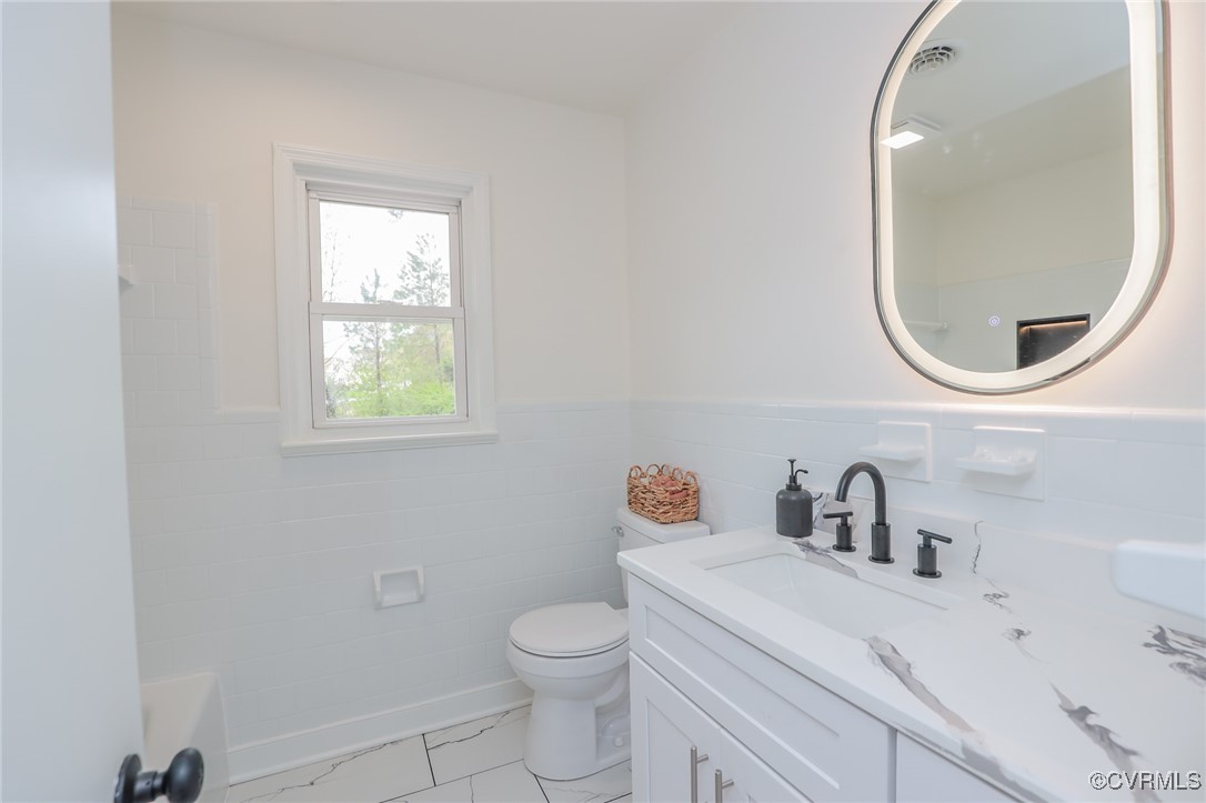 6626 Willson Road Henrico, VA 23231 - Photo 29 of 43 a bathroom with a toilet sink vanity and mirror