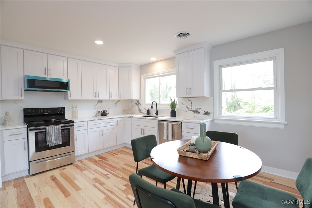 6626 Willson Road Henrico, VA 23231 - Photo 9 of 43 a kitchen with stainless steel appliances granite countertop a stove a kitchen island a table and a sink