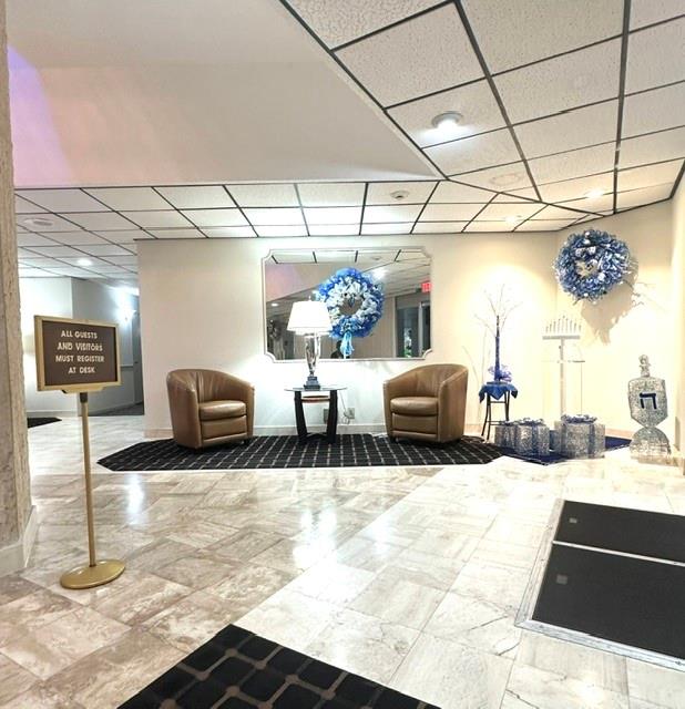 10777 West Sample Road, Unit 418 Coral Springs, FL 33065 - Photo 3 of 21 a lobby with furniture and a potted plant