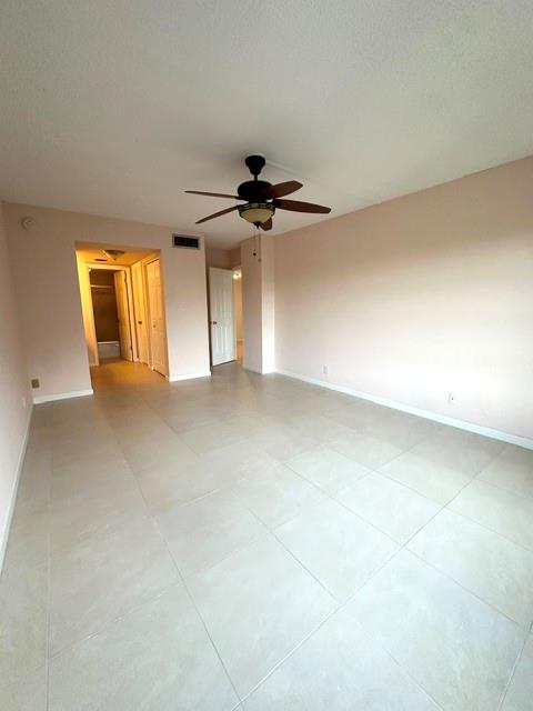 10777 West Sample Road, Unit 418 Coral Springs, FL 33065 - Photo 10 of 21 an empty room with windows and ceiling fan