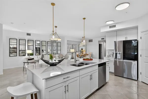 a kitchen with stainless steel appliances granite countertop a sink a stove and refrigerator