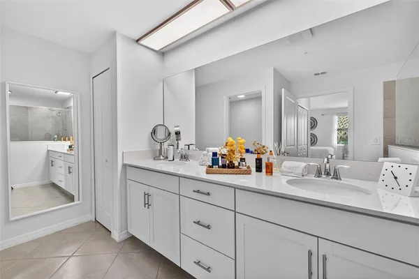a bathroom with a double vanity sink mirror and shower