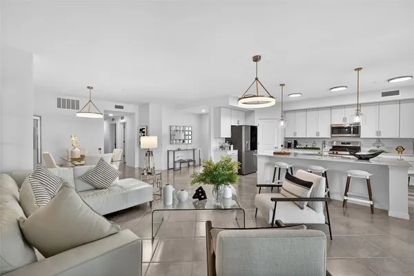 a living room with furniture a chandelier and kitchen view