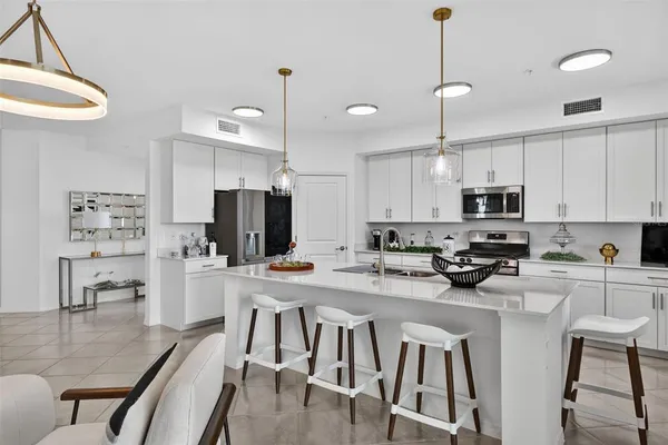 a kitchen with kitchen island granite countertop a stove a sink a oven a dining table and chairs
