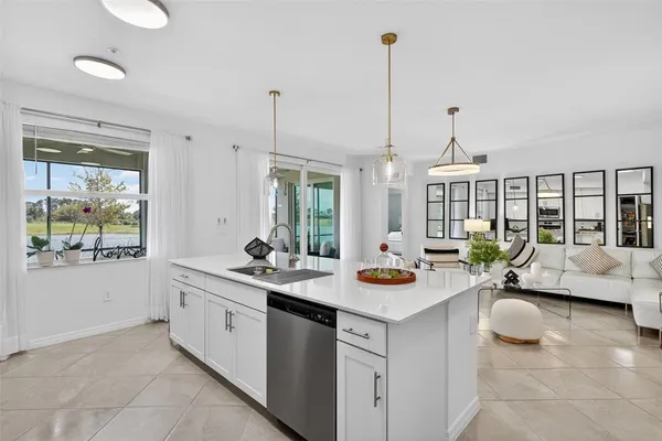 a kitchen with a sink a counter top space and living room view