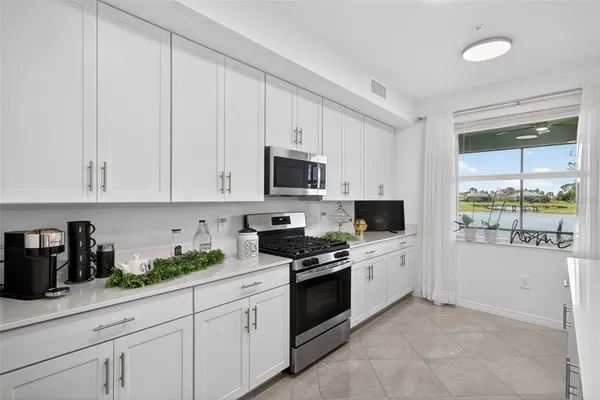 a kitchen with white cabinets and appliances