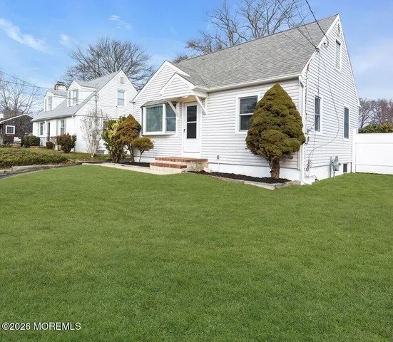 a front view of a house with a garden and yard