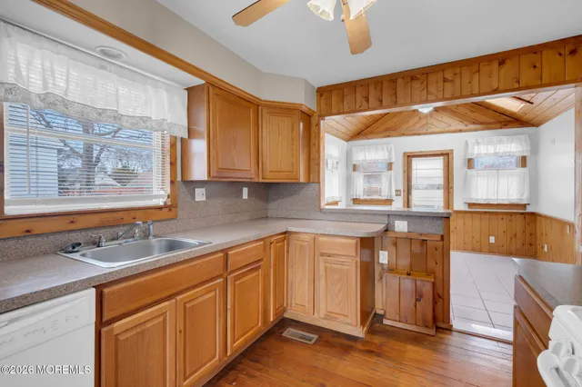a kitchen with stainless steel appliances granite countertop a sink and cabinets with wooden floor