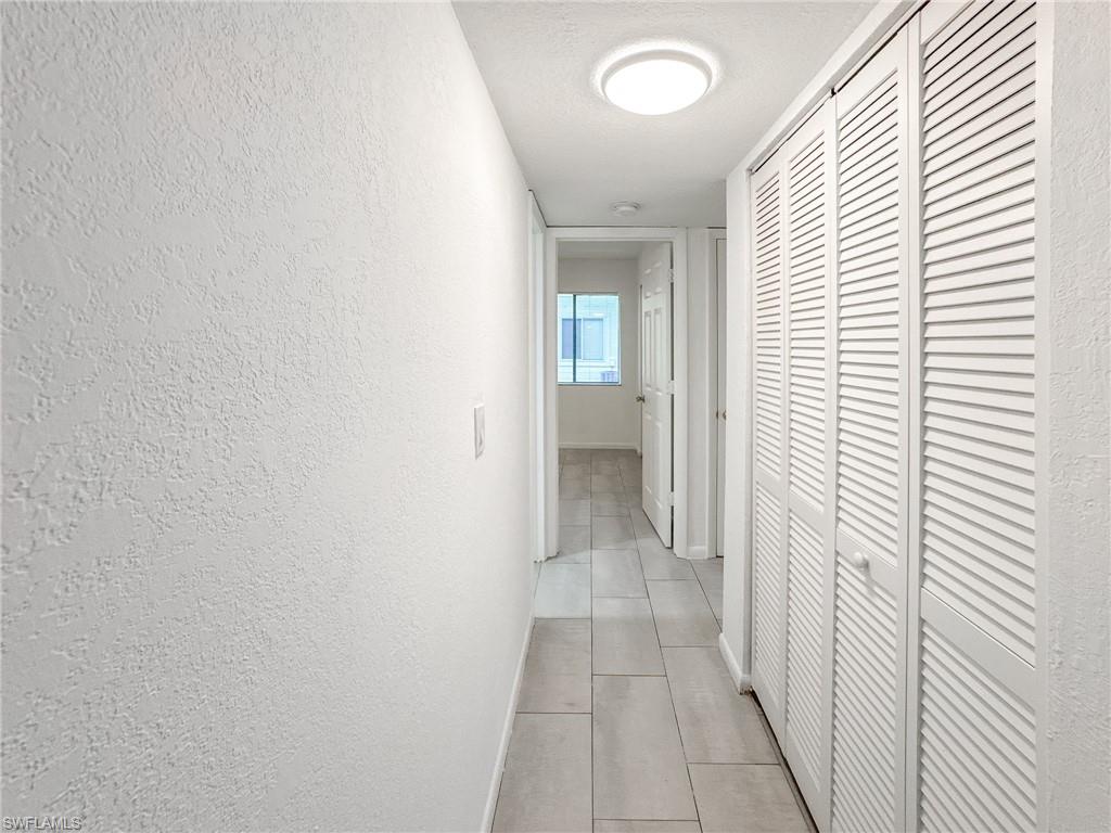 4631 Bayshore Drive, Unit L2 Naples, FL 34112 - Photo 17 of 41 a view of a hallway with a white walls and a window