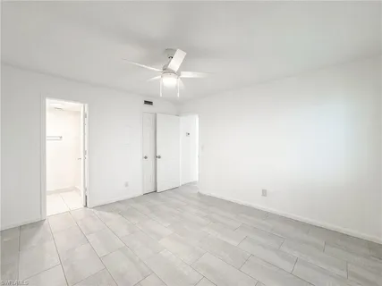 an empty room with an entryway and fan