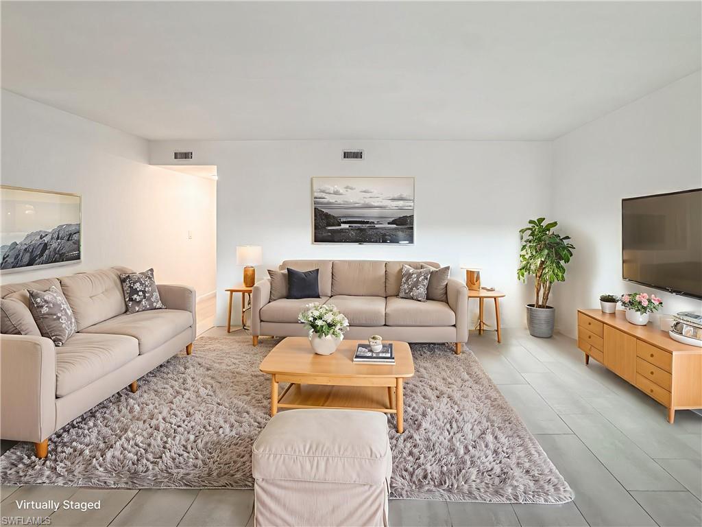 4631 Bayshore Drive, Unit L2 Naples, FL 34112 - Photo 2 of 41 a living room with furniture and a flat screen tv