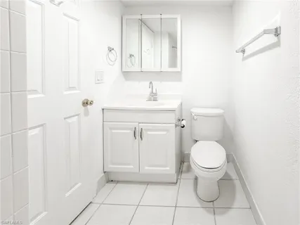 a bathroom with a toilet a sink and mirror