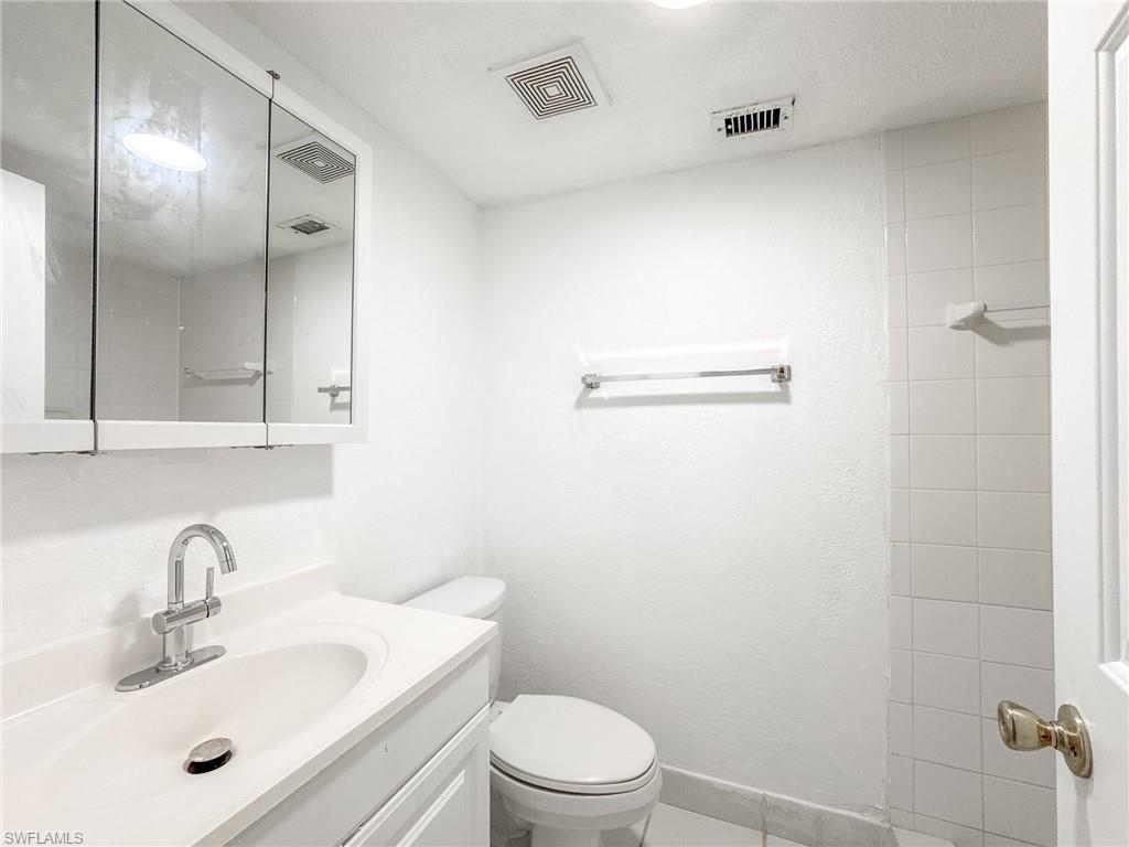4631 Bayshore Drive, Unit L2 Naples, FL 34112 - Photo 22 of 41 a bathroom with a sink a toilet and shower