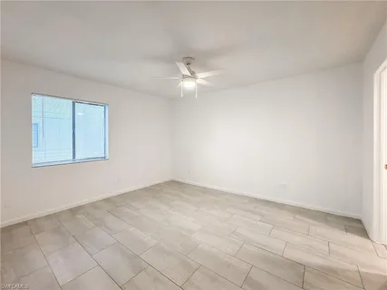 an empty room with a ceiling fan and a window