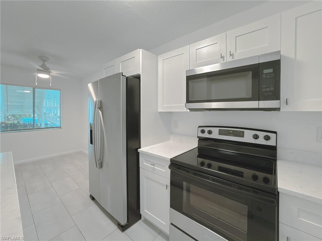 4631 Bayshore Drive, Unit L2 Naples, FL 34112 - Photo 6 of 41 a kitchen with cabinets and stainless steel appliances