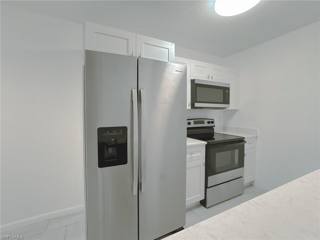 4631 Bayshore Drive, Unit L2 Naples, FL 34112 - Photo 8 of 41 a kitchen with stainless steel appliances a refrigerator and a stove top oven