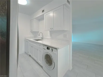 a utility room with sink dryer and washer