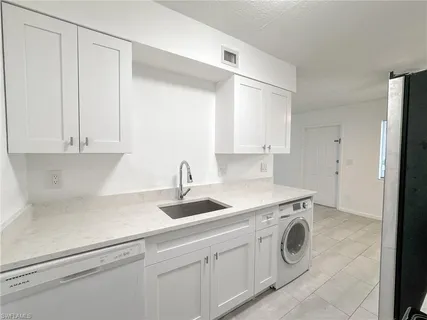 a kitchen with a sink and a washer dryer