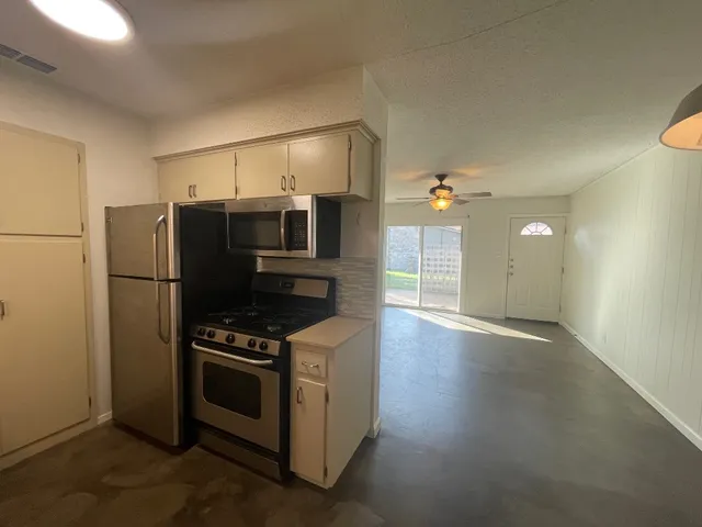 a kitchen with stainless steel appliances a refrigerator stove and microwave