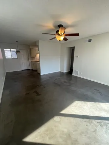 a view of a big room with wooden floor and a window