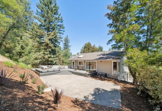 a view of a white house with a large tree