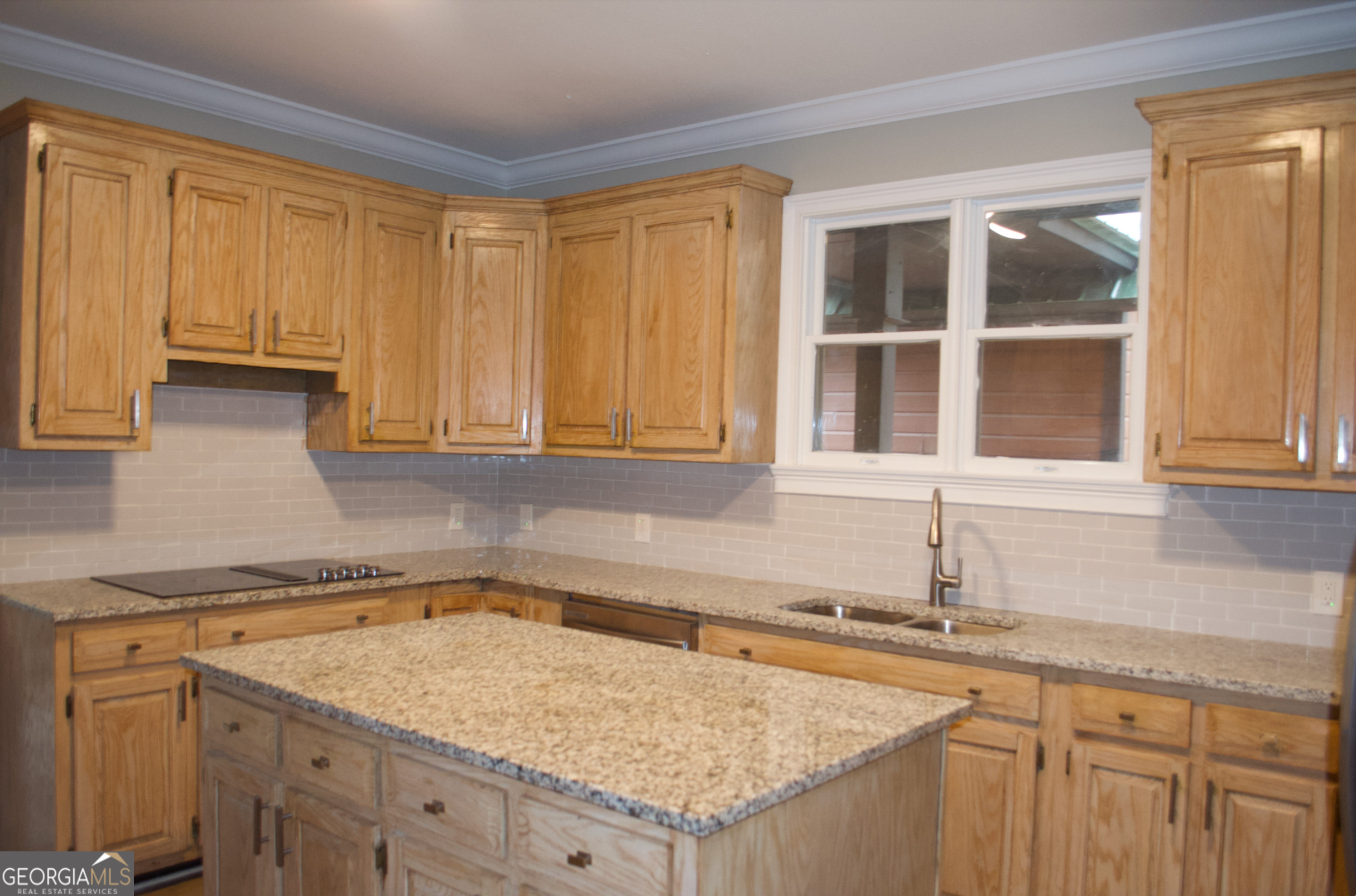 1206 Jasmine Road Dublin, GA 31021 - Photo 27 of 33 a kitchen with granite countertop sink and cabinets