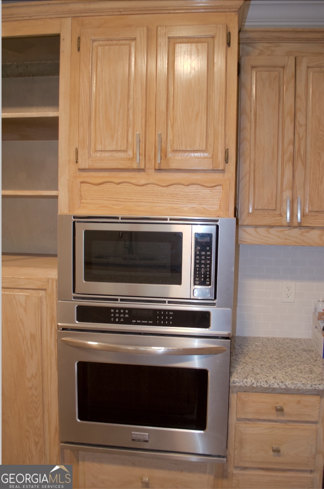 1206 Jasmine Road Dublin, GA 31021 - Photo 28 of 33 a kitchen with granite countertop white cabinets stainless steel appliances and counter space