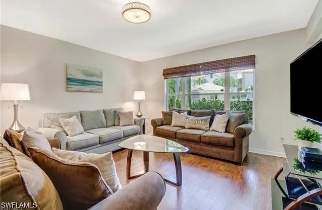 a living room with furniture flat screen tv and a large window