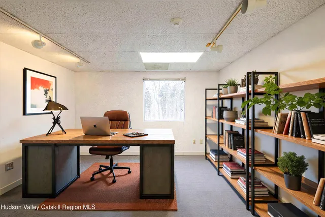 a view of a workspace with furniture and a window