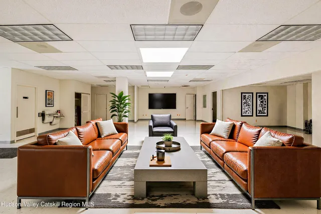 a living room with furniture a wooden floor and a flat screen tv