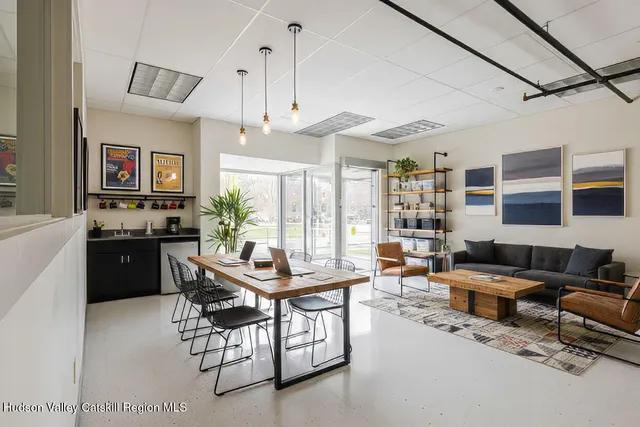 a living room with furniture kitchen view and a large window