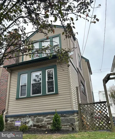 a front view of a house with a tree