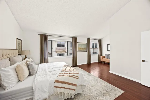 a large bedroom with a bed and wooden floor