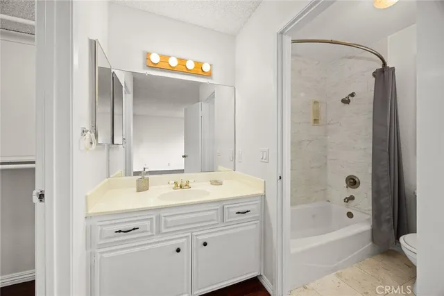 a bathroom with a sink a mirror a bathtub and shower