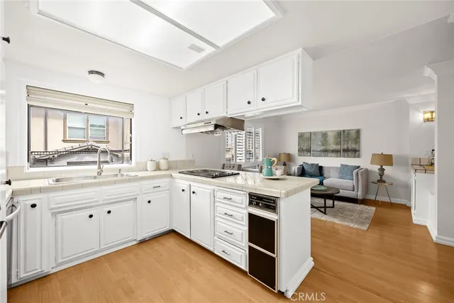 a open large kitchen with white cabinets and wooden floor