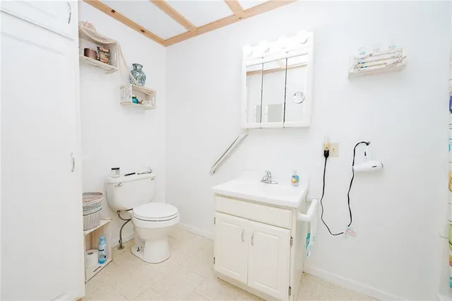a bathroom with a granite countertop toilet and a sink