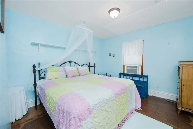 a bedroom with a bed and a flat tv screen on dresser